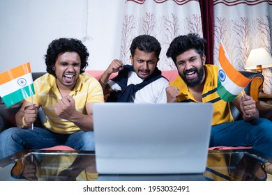 Three Young People Supporting Indian Team By Holding Indian Flags While Watching Live Streaming Cricket Match On Laptop