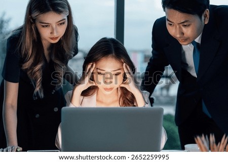 Three young professionals facing work stress while analyzing issue on laptop. Depicts digital workplace, corporate intensity, and business decision-making moments.