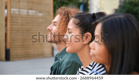 Three young professionals looking up at something with hope and expectation
