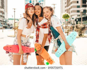 Three young smiling beautiful female with colorful penny skateboards. Women in summer hipster clothes posing in the street background. Positive models having fun and going crazy - Powered by Shutterstock