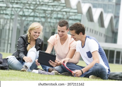 Three Young Student Laugh About Something On Their Ipad