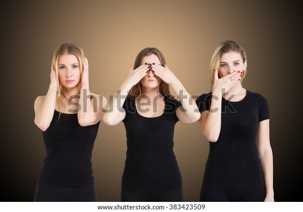 Three young woman in black clothes isolated at\
brown background showing blind, deaf: wise monkey scene - hear no\
evil, see no evil, speak no\
evil