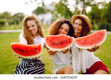 Three Young Woman  Camping On The Grass, Eating Watermelon, Laughing. People, Lifestyle, Travel, Nature And Vacations Concept.