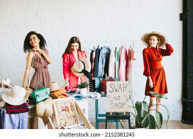 three young woman female caucasian and african students at swap party try on clothes, bags, shoes and accessories, change clothes with each other, second hand for things, zero waste life, eco-friendly - Shutterstock ID 2152381245