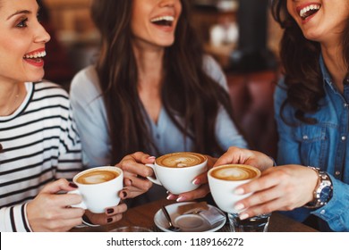 Three young women enjoy coffee at a coffee shop - Powered by Shutterstock