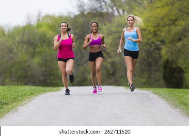 Three Young Women Jogging In A Park