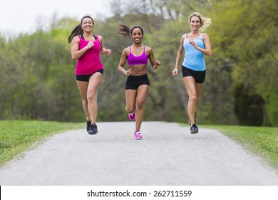 Three Young Women Jogging In A Park