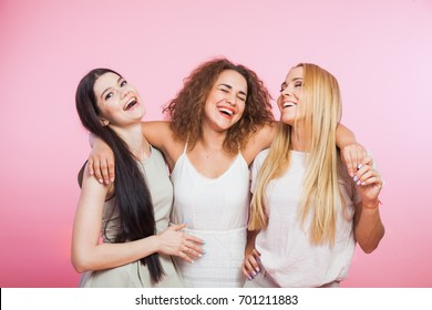 Three Young Women Laughing And Having Fun Together. Girlfriends Hugging And Smiling Happily. Female Company Of Best Friends. Blonde Curly Brown And Long Dark Hair.