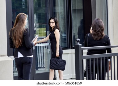 Three Young Women Standing In Front Of Doorway To Office Building Ready To Enter