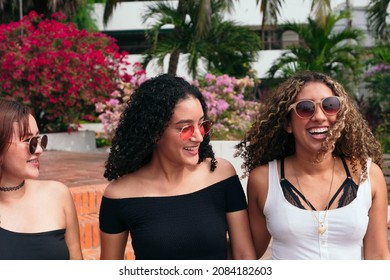 Three Young Women Walking Down The Street Together