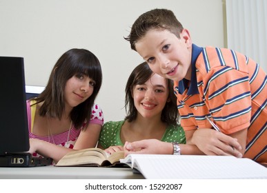 Three youngsters who appear to be studying or doing homework together.