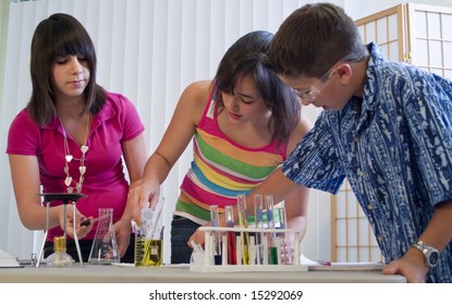 Three youngsters working together on what appears to be a science or chemistry project.