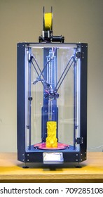 Three-axis 3D printer. nside stands a model of a vase of yellow color