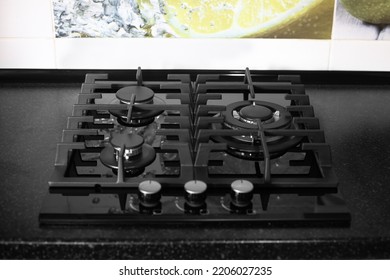 A Three-burner Gas Stove With A Tempered Glass Top Is Built Into A Black Countertop In The Kitchen. Selective Focus.