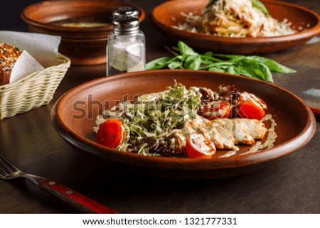 Three-course dinner, tea and a bun. The table is decorated with greens. In the foreground salad with chicken breast. Clouse-up.