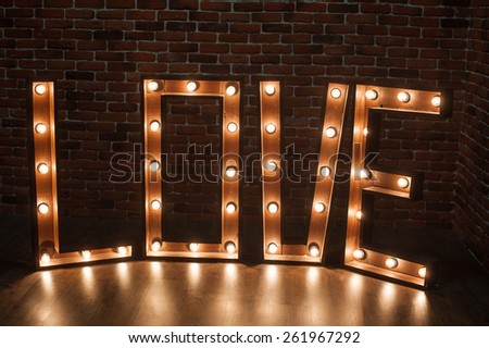 Three-dimensional letter LOVE with glowing lights.