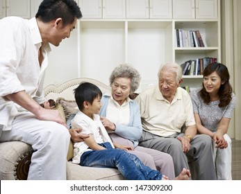 Three-generation Asian Family Talking In Living Room.