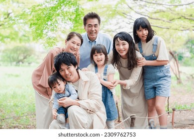 A three-generation family living happily with smiles on their faces - Powered by Shutterstock