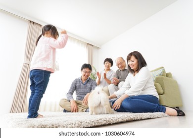 Three-generation Family Playing With Dog