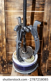 Three-jaw gear puller removing an overrunning clutch from an electric bicycle motor hub for maintenance and mechanical repair on a rustic wooden workshop background