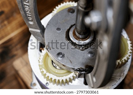 Three-jaw gear puller removing an overrunning clutch from a geared electric motor wheel, close-up shot of professional workshop maintenance and mechanical repair of an e-bike hub drive