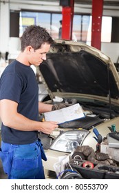Three-quarter Length Of Mechanic Holding A Work Order