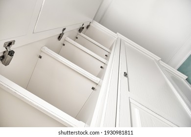 Three-section white wardrobe in classic style with inner shelves in a modern hallway low angle view