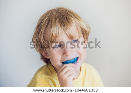 Three-year old boy shows myofunctional trainer to illuminate mouth breathing habit. Helps equalize the growing teeth and correct bite. Corrects the position of the tongue