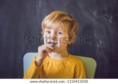 Three-year old boy shows myofunctional trainer. Helps equalize the growing teeth and correct bite, develop mouth breathing habit. Corrects the position of the tongue