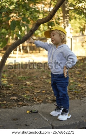 Three-year-old boy pointing at something in the park