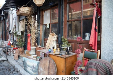 Thrift Store On A Side Street In The Historic Neighborhood Of Korce, Albania. The Old Ottoman Bazaar. Items For Sale On The Sidewalk.