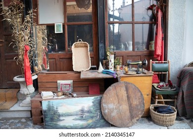 Thrift Store On A Side Street In The Historic Neighborhood Of Korce, Albania. The Old Ottoman Bazaar. Items For Sale On The Sidewalk.