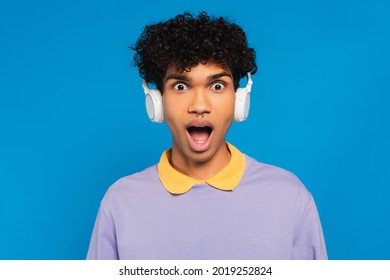 thrilled african american man in wireless headphones looking at camera isolated on blue - Shutterstock ID 2019252824