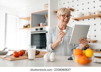 Thrilled blonde senior white woman searching for online breakfast recipe on digital tablet. - Powered by Shutterstock