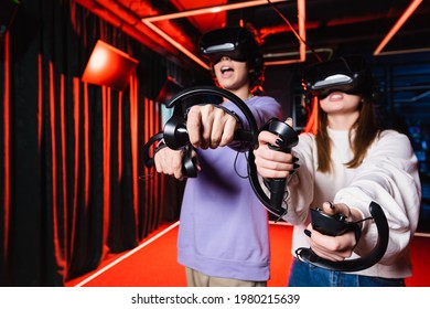 thrilled teenage gamers in vr headsets having fun in play zone - Powered by Shutterstock