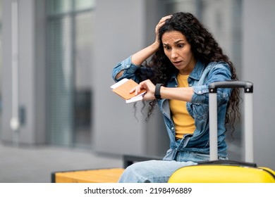 Thrilled Young Curly Woman Tourist Sitting On Bench, Waiting For Taxi, Checking Time, Looking At Smart Watch And Touching Her Head, Traveller Running Late For Her Flight, Bus Or Train, Copy Space