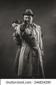 Thriller Film Noir Scene With Man Pointing A Gun And Woman Hiding Behind Him