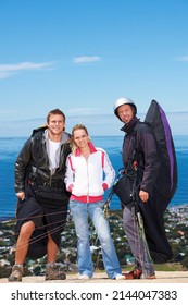 Thrillseekers. Three Paragliders Posing For The Camera Before Jumping.