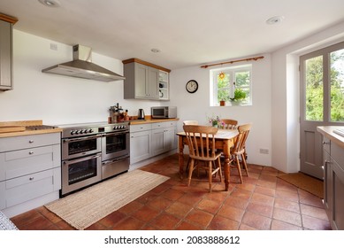 Thriplow, Cambridgeshire, England - August 9 2019: Cottage Kitchen With Built In Traditional Styled Cabinetry, Terracotta Tiled Floors And White Painted Walls.