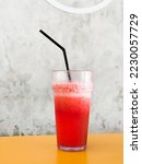 Thrist quencher cold fresh watermelon juice isolated in a concreate background. A dewy glass look