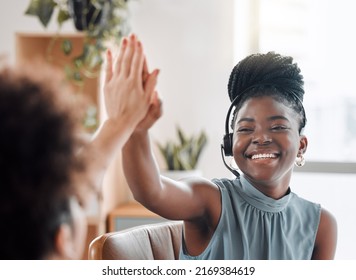 Thriving Through Teamwork. Shot Of Two Call Centre Agents Giving Each Other A High Five While Working In An Office.