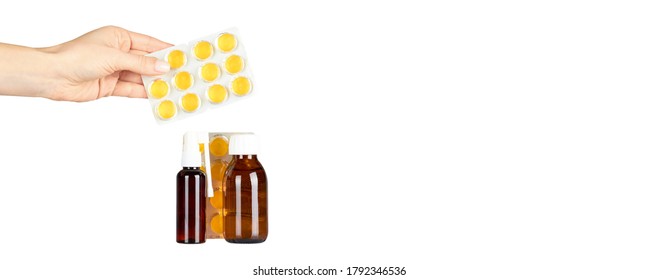 Throat ache pills in bister, spray and syrup with hand, isolated on white background. Copy space template, banner. - Shutterstock ID 1792346536