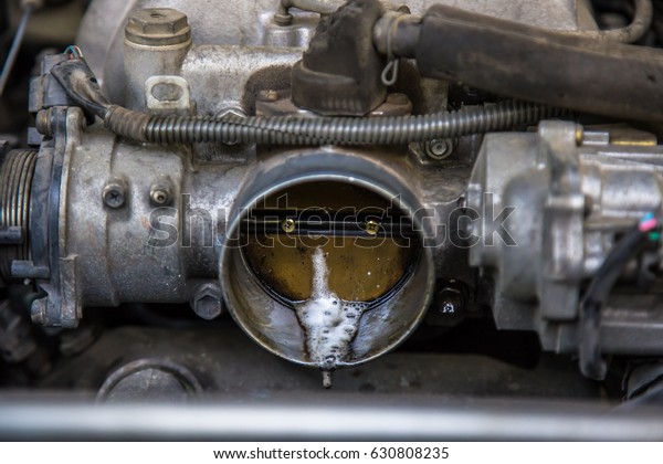 throttle valve is controlled with a throttle pedal or\
lever via a direct mechanical linkage.\
A fragment of the engine\
car that old and shabby. hand of mechanic is to clean your car\'s\
engine safely 