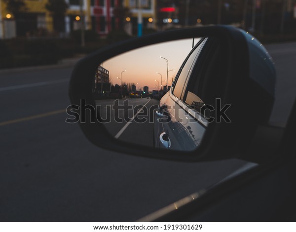 Through the car window to see the sunset glow of\
the sky reflected in the\
mirror