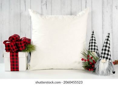 Throw pillow cushion product mockup. Christmas farmhouse theme SVG craft product mockup styled with gift with buffalo plaid bow and farmhouse style gnomes against a white wood background.