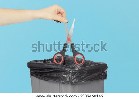 throw scissors into the trash bin, scissors in hand in front of trash can, tool wear concept