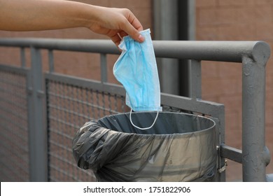 Throw Surgical Mask In Public Garbage Can In City Street. Hygienic Mask Puts In The Trash.