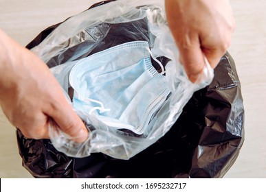 Throwing away single use medical  face mask. Packing it in one time plastic bag before throwing it in trash to prevent virus from spreading from mask to trash can and to people. 