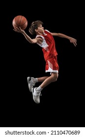 Throwing A Ball Ino Basket. Portrait Of Teen Boy, Basketball Player In Motion, Training, Playing Isolated Over Black Background. Concept Of Sport, Active Lifestyle, Health, Team Game And Ad