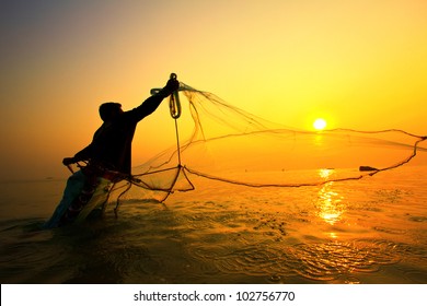 throwing fishing net during sunrise